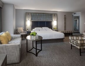 Spacious king guest room with sitting area, modern furnishings, and city-view windows at Hyatt Regency Boston.