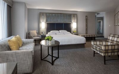 Spacious king guest room with sitting area, modern furnishings, and city-view windows at Hyatt Regency Boston.