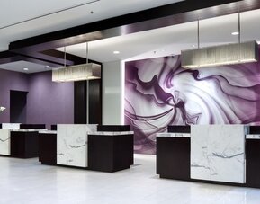 Modern hotel reception area with marble-front desks and purple accent wall at Hyatt Regency Boston.