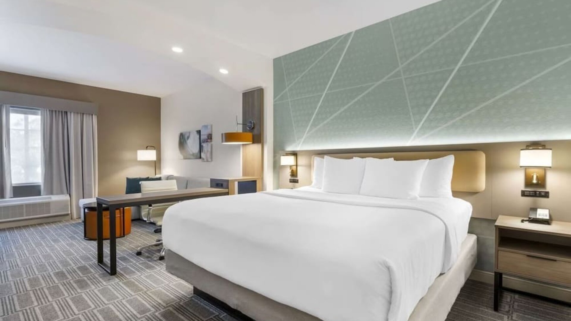 Spacious king suite with dedicated workspace, lounge seating, and modern furnishings at Comfort Inn & Suites Port Charlotte-Punta Gorda.
