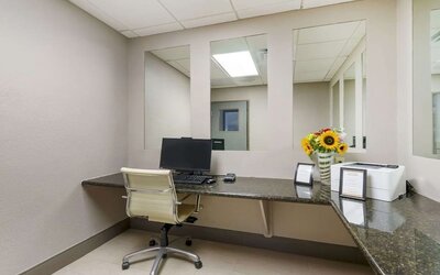 Compact business center with desktop workstation, printer access, and granite work surfaces at Comfort Inn & Suites Port Charlotte-Punta Gorda.