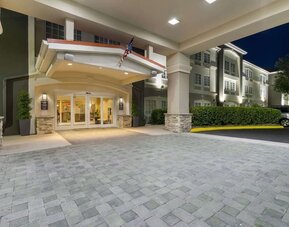 Covered hotel entrance illuminated at night with landscaped surroundings at Comfort Inn & Suites Port Charlotte-Punta Gorda.