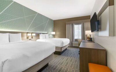 Double queen guest room with modern furnishings and spacious layout at Comfort Inn & Suites Port Charlotte-Punta Gorda.