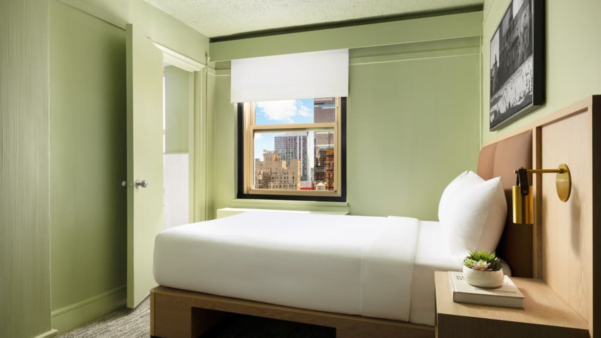 Cozy guest room with natural light, city views, and minimalist modern furnishings at Row NYC.