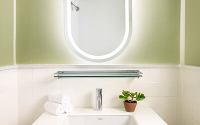 Modern bathroom vanity with illuminated mirror, contemporary sink, and minimalist styling at Row NYC.