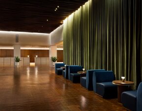 Elegant reception and lounge area with plush seating, dramatic curtains, and sophisticated lighting at Row NYC.