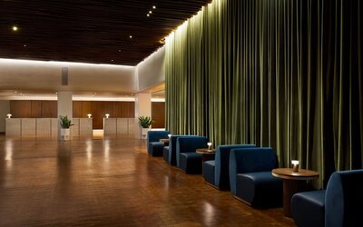 Elegant reception and lounge area with plush seating, dramatic curtains, and sophisticated lighting at Row NYC.