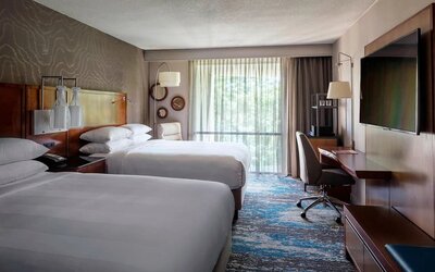 Contemporary double guest room with two comfortable beds, workspace, and large window views at Boston Marriott Newton.