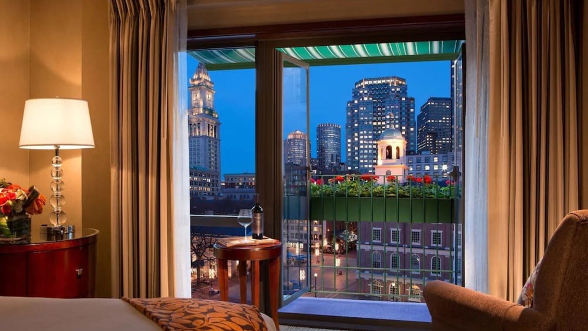Guest room with scenic balcony and panoramic Boston skyline views at The Bostonian Boston, A Millennium Hotel.
