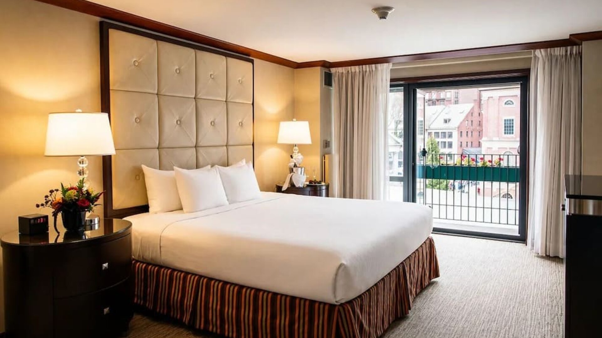 Elegant king guest room with plush bedding, spacious layout, and balcony views at The Bostonian Boston, A Millennium Hotel.