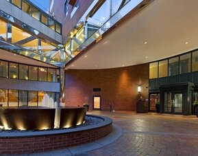 Grand hotel entrance courtyard with modern fountain feature and contemporary architectural design at The Bostonian Boston, A Millennium Hotel.