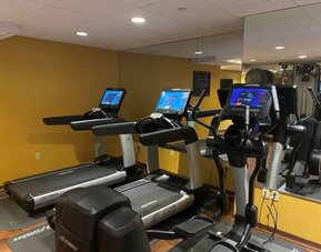 Modern hotel gym with treadmills, elliptical machines, and mirrored workout space at The Bostonian Boston, A Millennium Hotel.