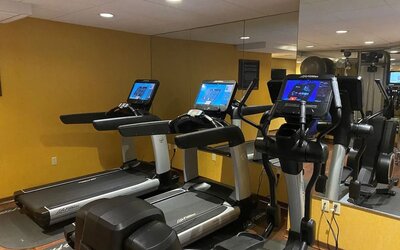 Modern hotel gym with treadmills, elliptical machines, and mirrored workout space at The Bostonian Boston, A Millennium Hotel.