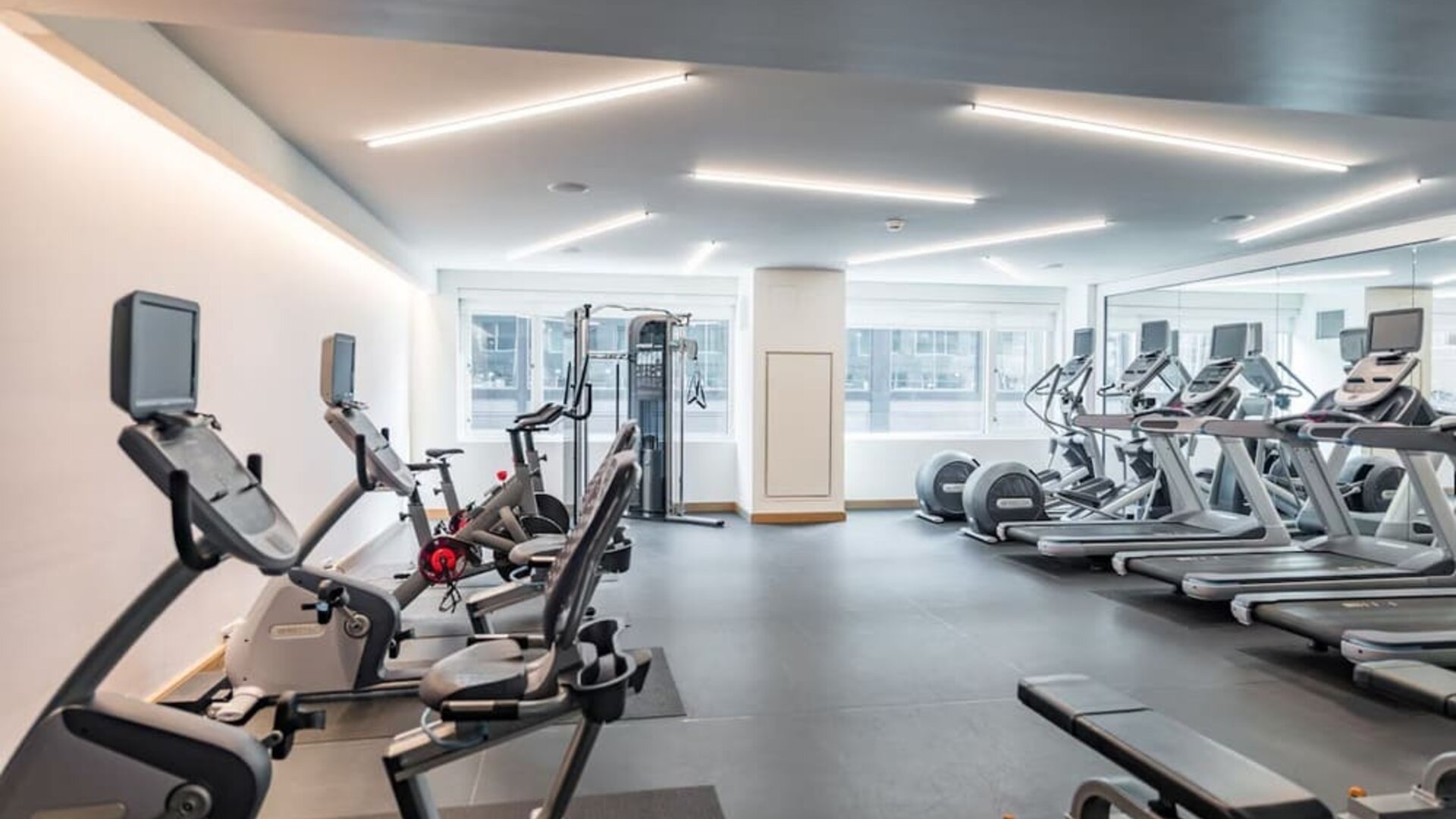 Bright and spacious fitness center equipped with cardio machines, free weights, and modern workout facilities at The Envoy Hotel, Autograph Collection.