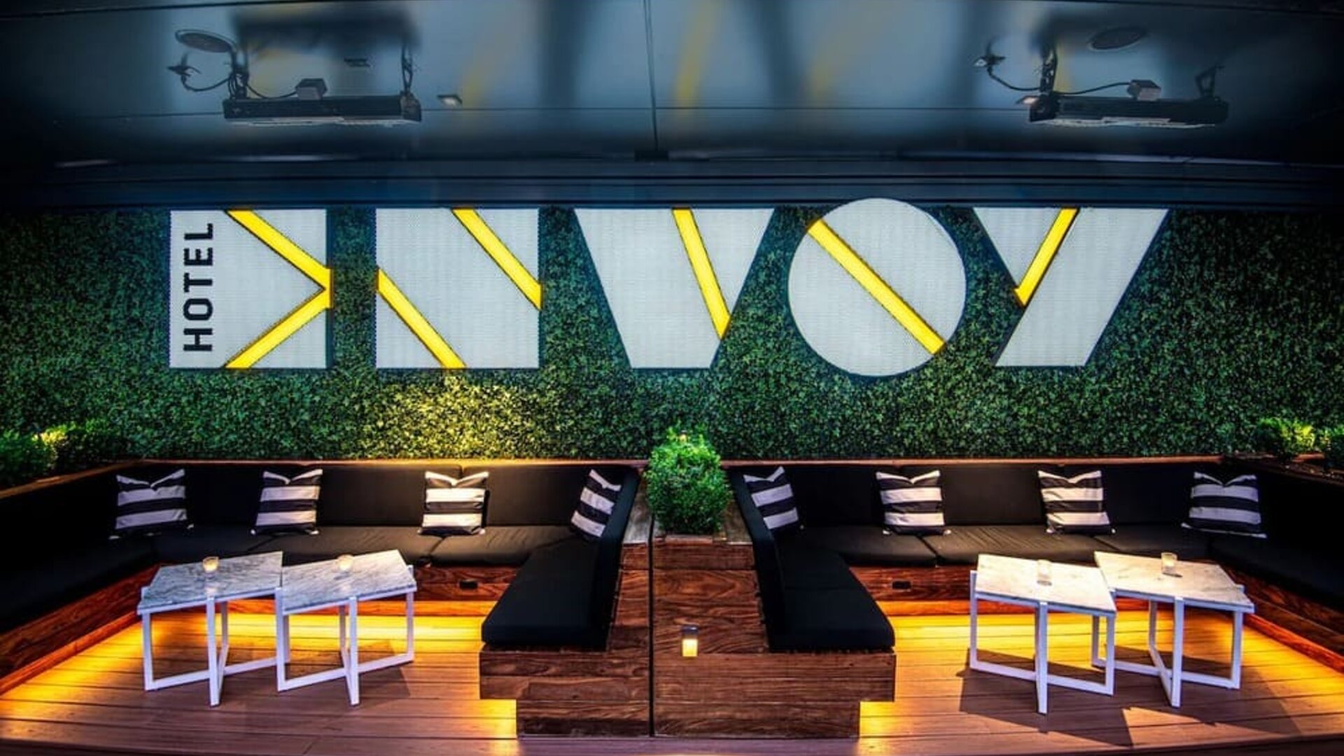 Trendy rooftop lounge area with illuminated seating, modern décor, and vibrant nightlife atmosphere at The Envoy Hotel, Autograph Collection.