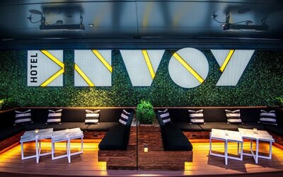 Trendy rooftop lounge area with illuminated seating, modern décor, and vibrant nightlife atmosphere at The Envoy Hotel, Autograph Collection.