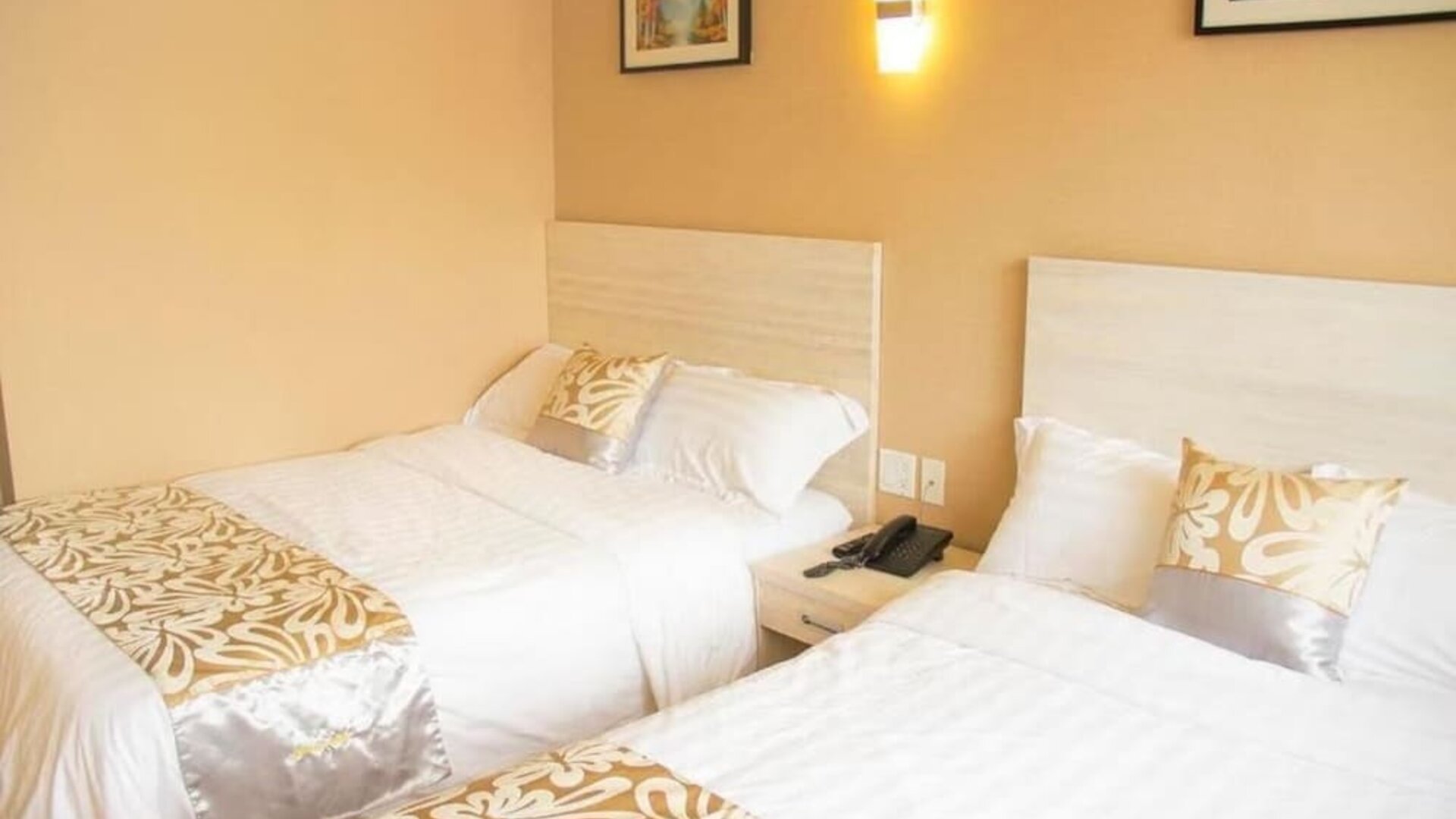 Double-bed guest room with warm lighting and contemporary furnishings at Phoenix Hotel Brooklyn Sunset Park.