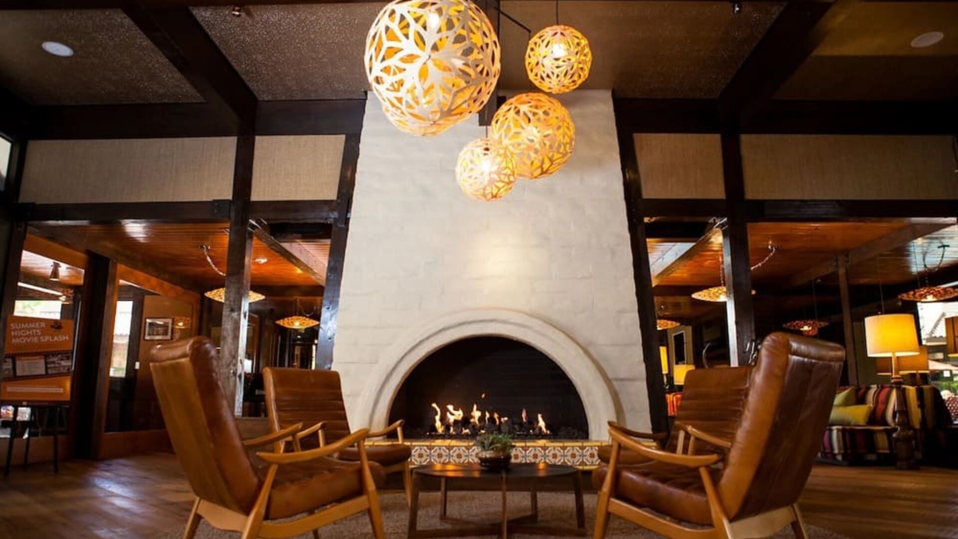 Cozy lobby fireplace lounge with modern lighting, leather seating, and warm communal gathering spaces at The Garland.