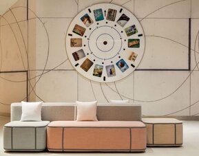 Modern lobby seating area showcasing artistic design elements, soft pastel furnishings, and a welcoming atmosphere for guests.
