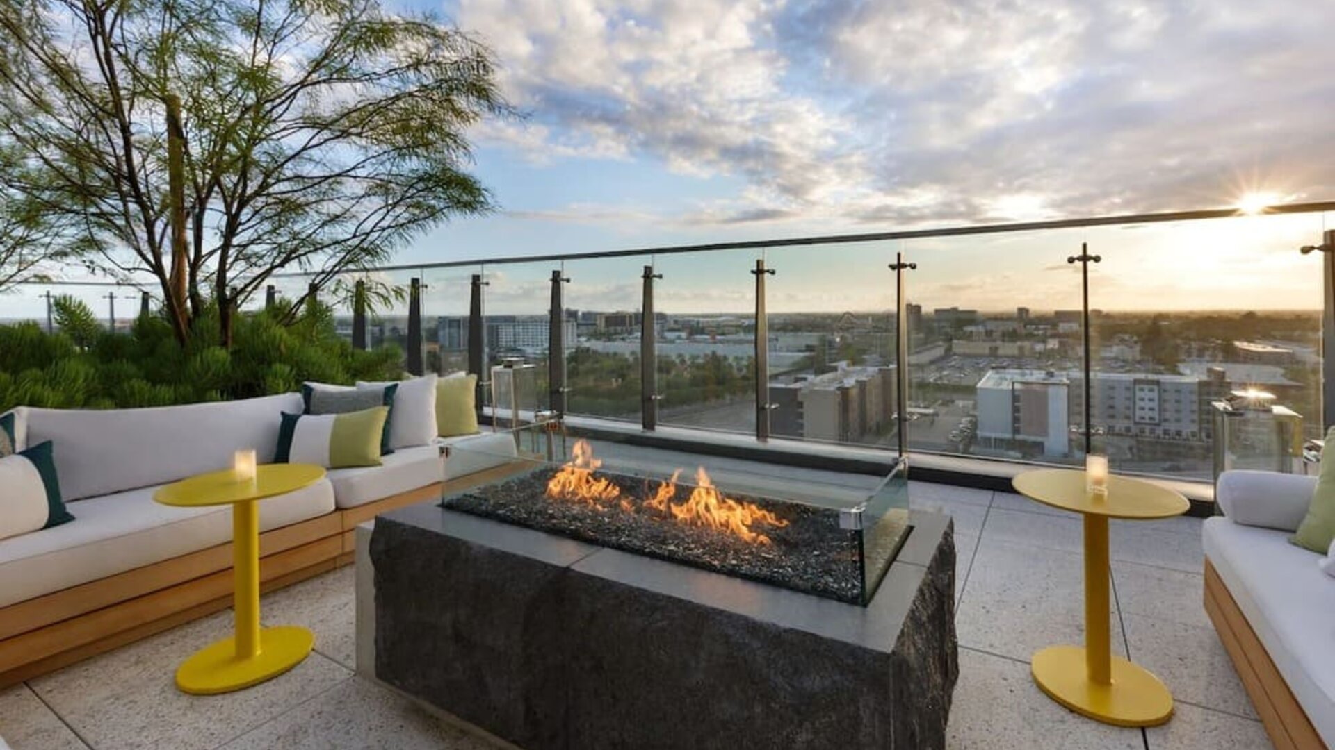 Rooftop terrace with fire pit seating, city views, and comfortable outdoor lounges, ideal for social gatherings and sunset relaxation.